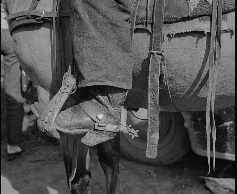 detail of a cowboy boot in stirrup